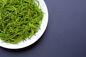 Climbing Wattle or Acacia leaves on dark background.