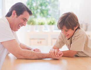 Father and son (10-11 years) arm wrestling