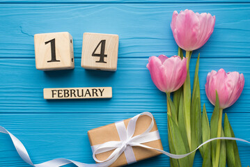 Happy st valentine day concept. Flat lay close up top above overhead view photo picture of tender tulips with ribbon and wooden cube calendar on bright wooden desk