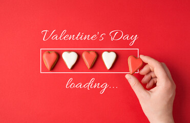 Valentines day is almost here concept. Flatlay close up view photo image of female hand holding putting yummy cookies in a row isolated bright color red table desk