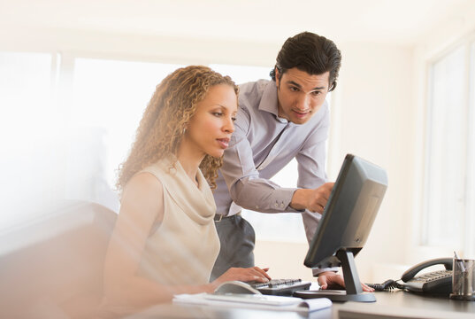 Business man and woman looking at computer