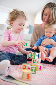 Mother playing with children (2-3, 6-11 months) at home