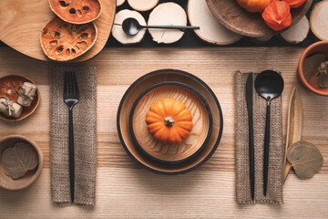 Autumn table setting with pumpkin on wooden background, flat lay
