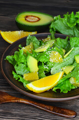 fresh summer homemade salad of vegetables and fruits, orange, lettuce, avocado and sesame seeds, healthy food, organic, vegetarian eco health and immunity products
