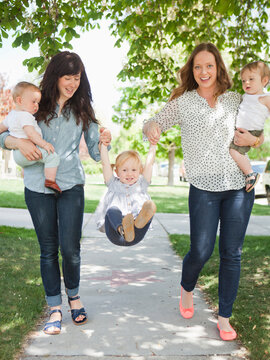 USA, Utah, Salt Lake City, Two young mothers walking with two baby boys (6-11 months) and toddler girl (2-3)
