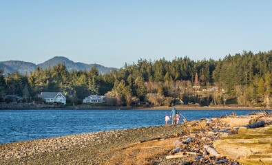 Family walking along rugged ocean shore in Sooke BC Canada 