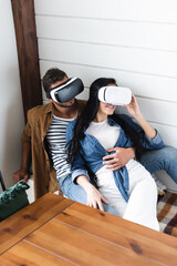 Fototapeta na wymiar young man hugging girlfriend smiling while gaming in vr headset