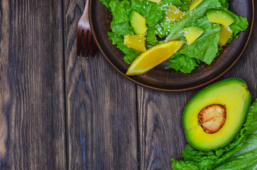 fresh summer homemade salad of vegetables and fruits, orange, lettuce, avocado and sesame seeds, healthy food, organic, vegetarian eco health and immunity products