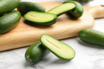 Fresh seedless avocados on marble table, closeup