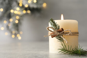 Burning candle with pinecone scent on light grey table, closeup. Space for text