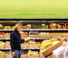Young man buying vegetables and fruits at the market.