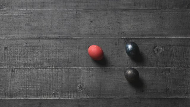 female hands put Easter eggs on a wooden table