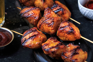Chicken kebab skewers. Chicken shish kebab on dark board on dark background. Grilled Chicken.