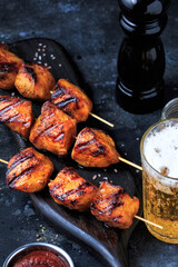 Easy and Delicious Chicken kebabs. Grilled Chicken on bamboo Skewers served with a drink. Dark Background