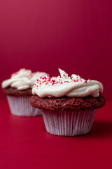 closeup of red cupcake on a plain red background 