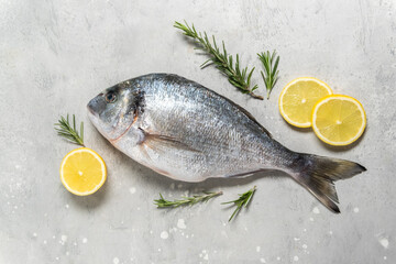 Fresh fish dorado or sea bream with ingredients for cooking  flat lay composition . Healthy food concept. Top view with copy space.