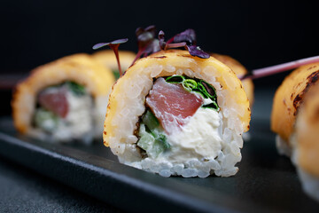 Japanese restaurant menu photo, seafood, national cuisine. Tuna and cheese sushi rolls set served on plate, food background