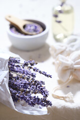 Close-up on dry lavender flowers in white tracing paper. Hand made lavender sachets on cotton...