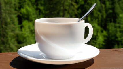 Closeup of cup of coffee on wooden handrails of mountain hotel balcony or terrace