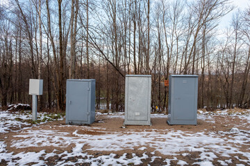 electrical cabinets standing on the side of the road are gray and dark