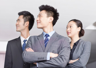 Four young office workers with hands crossed indoors,portrait