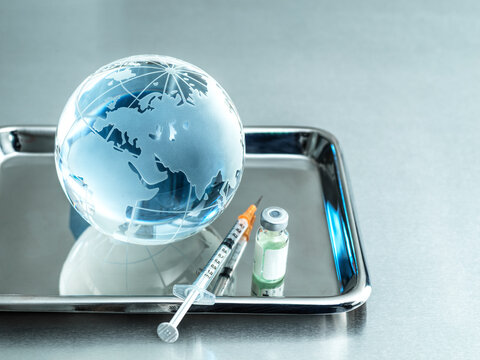 Glass globe with injection and vial in tray on table