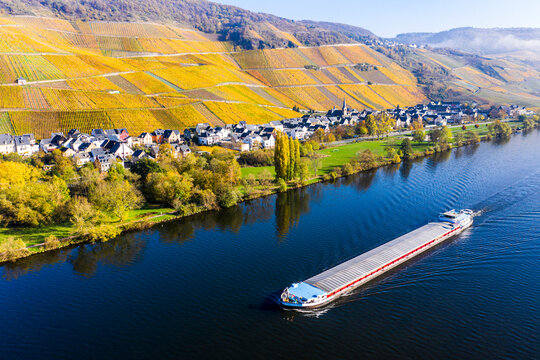 Germany, Rhineland-Palatinate, Bernkastel-Kues, Helicopter view of barge sailing along Middle Moselle with rural town in background