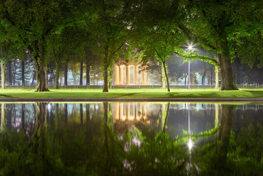 USA, Washington DC, Trees reflecting in Lincoln Memorial Reflecting Pool at night with District of Columbia War Memorial in background