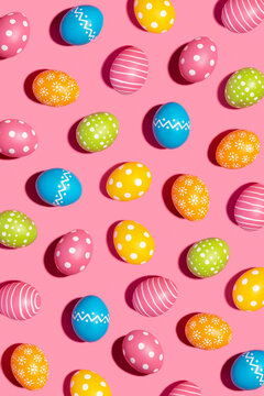 Colorful decorated Easter eggs on pink background