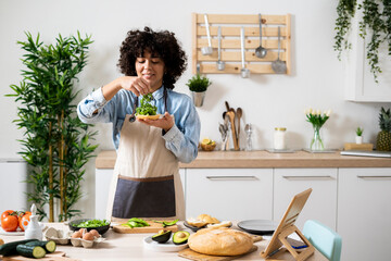 Portrait of young woman preparing vegan sandwiches in kitchen