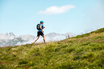 Determinant male athlete running on meadow, Picos De Europa National Park, Santa Marina de Valdeon, Castille and Leon, Spain