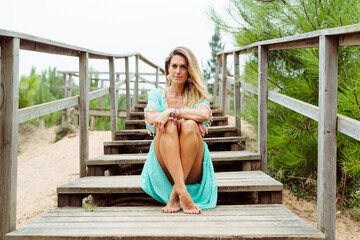 Mid adult woman sitting with legs crossed at ankle on steps at forest