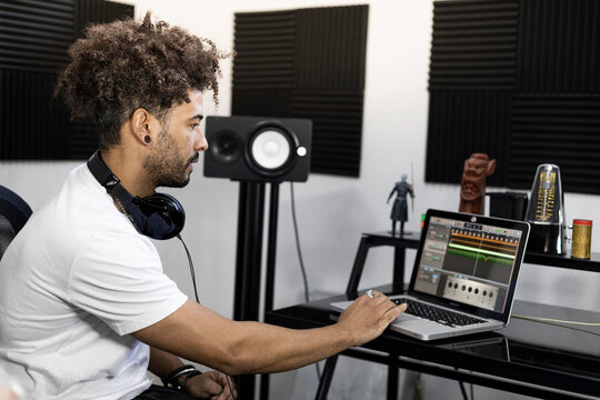 Man with headphones working on laptop while sitting at home