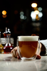 Glass of irish coffee on a table. classic irish coffee saved on a dark bar with a float of heavy cream