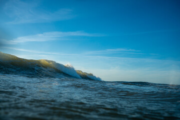 Breaking Waves and spray, white water and light reflected on the surface of the water