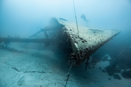 Diver examining underwater shipwreck
