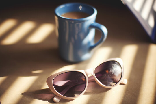 Sunglasses and mug of coffee