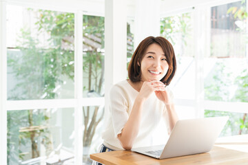 Obraz premium 部屋でラップトップコンピューターを見る女性