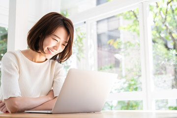 部屋でラップトップコンピューターを見る女性