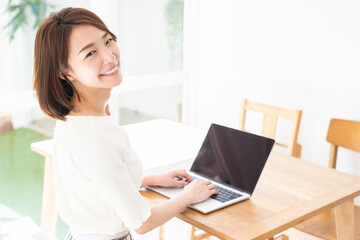 部屋でラップトップコンピューターを見る女性