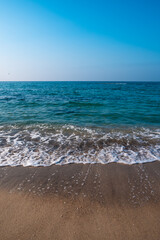 Seascape. Waves running on the sandy shore. Shore of the sea or ocean on a nice day. Vacation and relaxation by the sea.