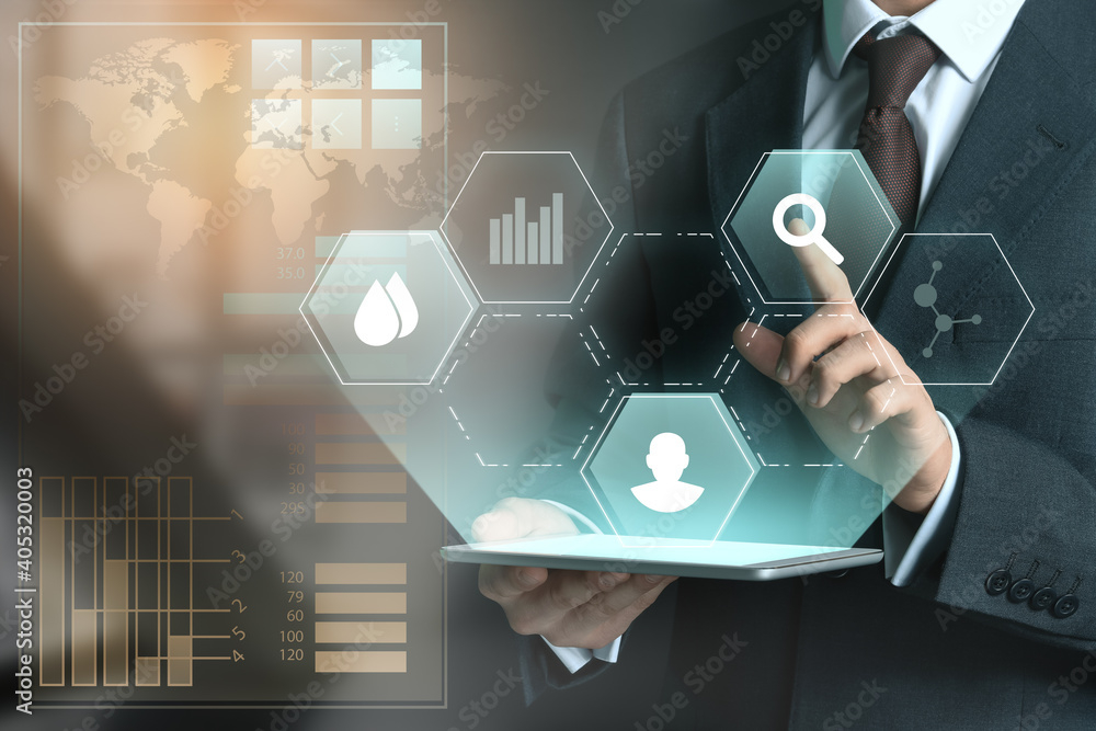 Poster businessman with tablet computer using virtual screen on dark background