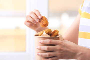 Woman with bucket of tasty nuggets, closeup © Pixel-Shot