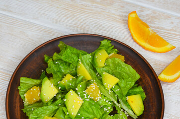 fresh summer homemade salad of vegetables and fruits, orange, lettuce, avocado and sesame seeds, healthy food, organic, vegetarian eco health and immunity products