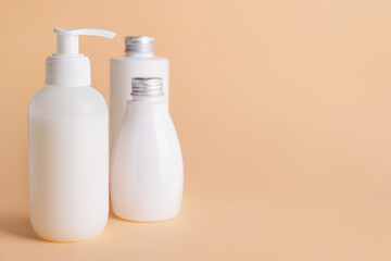 Different bottles of cosmetic products on color background