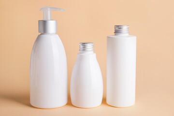 Different bottles of cosmetic products on color background