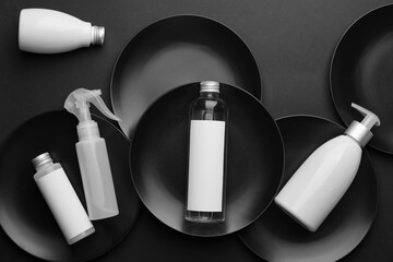 Different bottles of cosmetic products on dark background