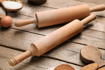 Ingredients for cookies and rolling pins on wooden background