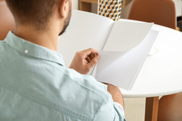 Young man reading magazine at home