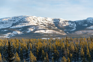 Stunning winter landscape in northern Canada during snowy, freezing cold season. Stunning winter landscape in northern Canada during snowy, freezing cold season. Snow covered mountains above a boreal 